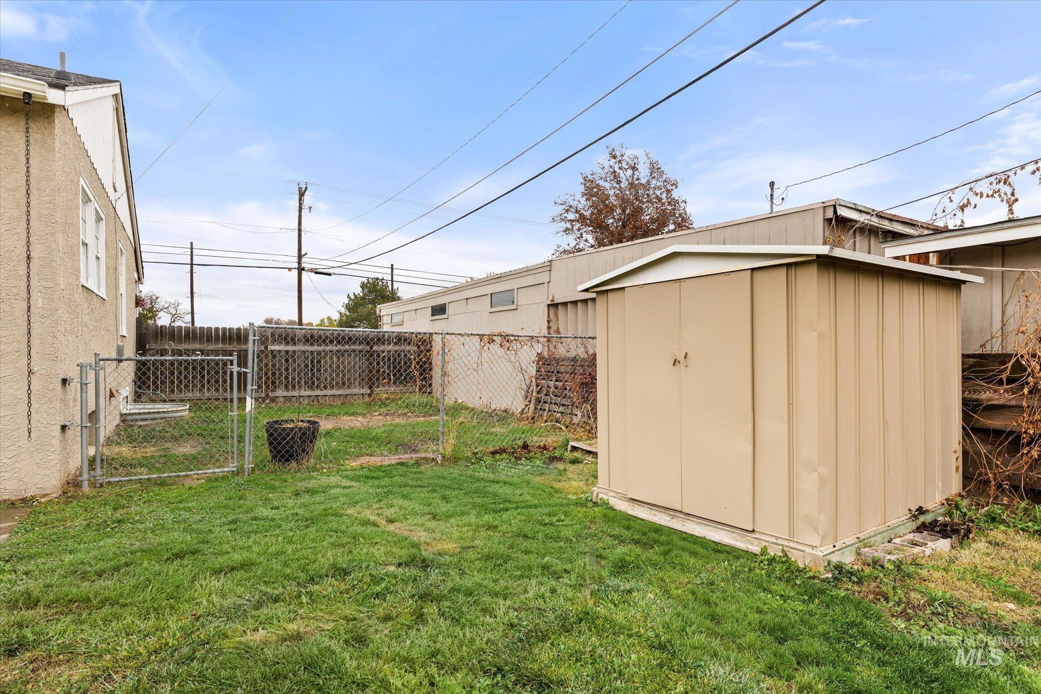 Fenced backyard with a gate and a shed