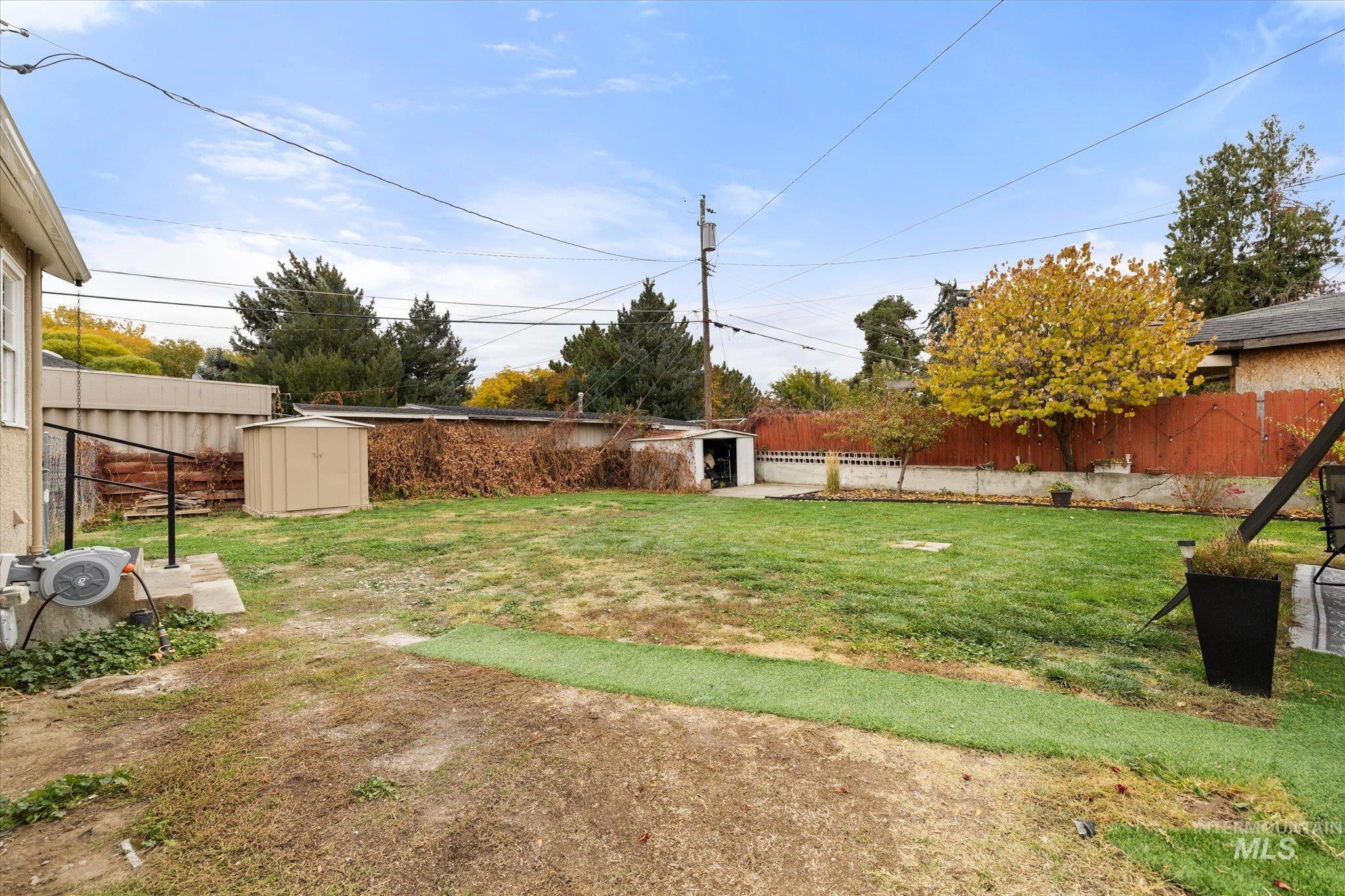 Fenced backyard with a storage unit