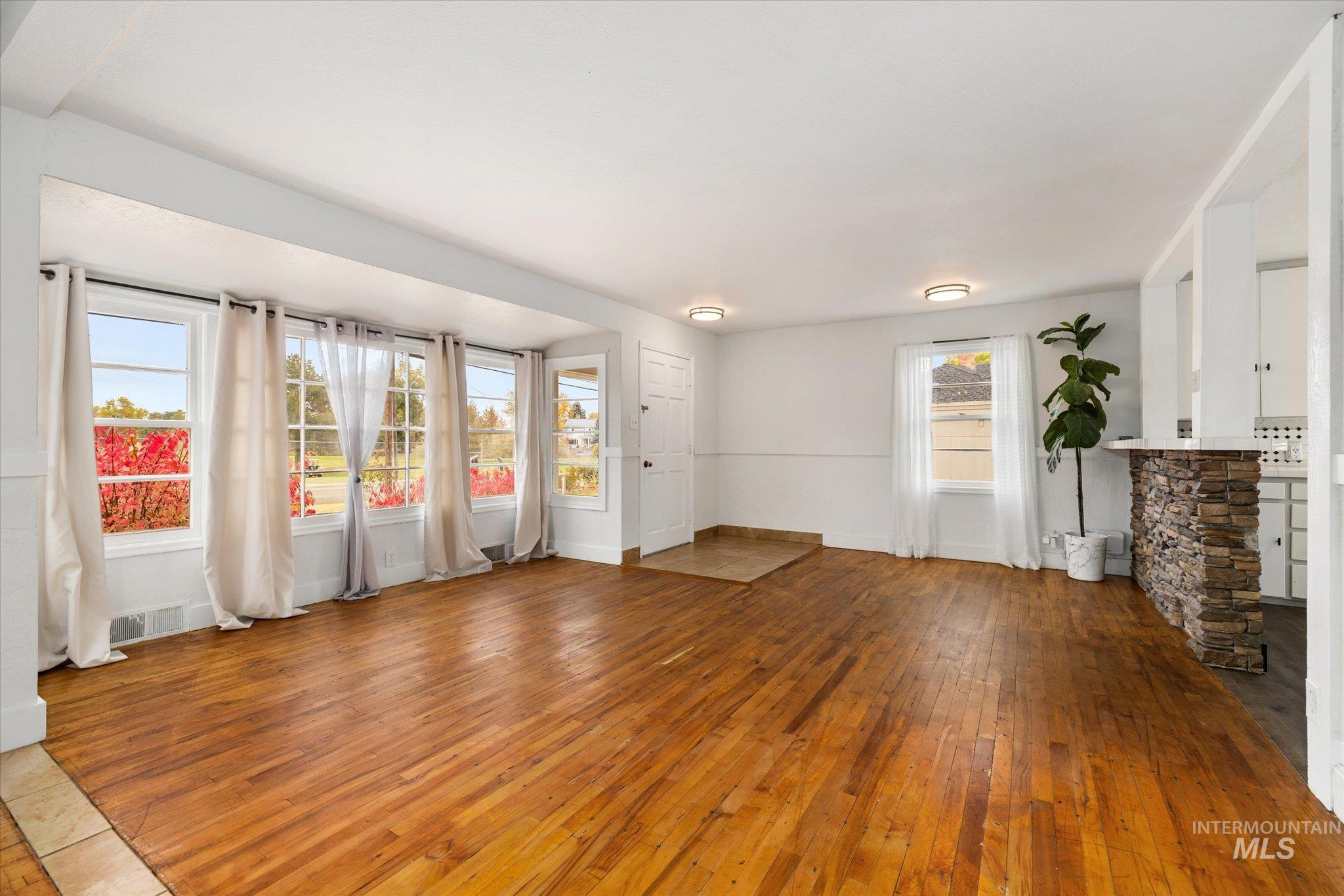 Unfurnished living room with hardwood / wood-style flooring and baseboards