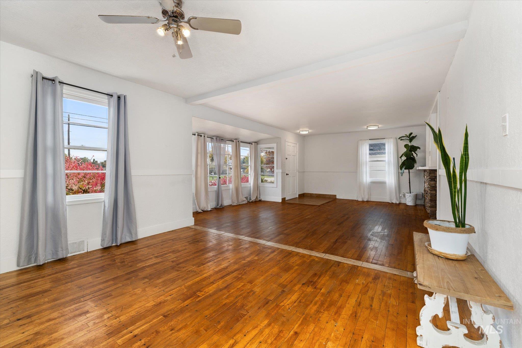 Unfurnished living room with wood-type flooring and ceiling fan