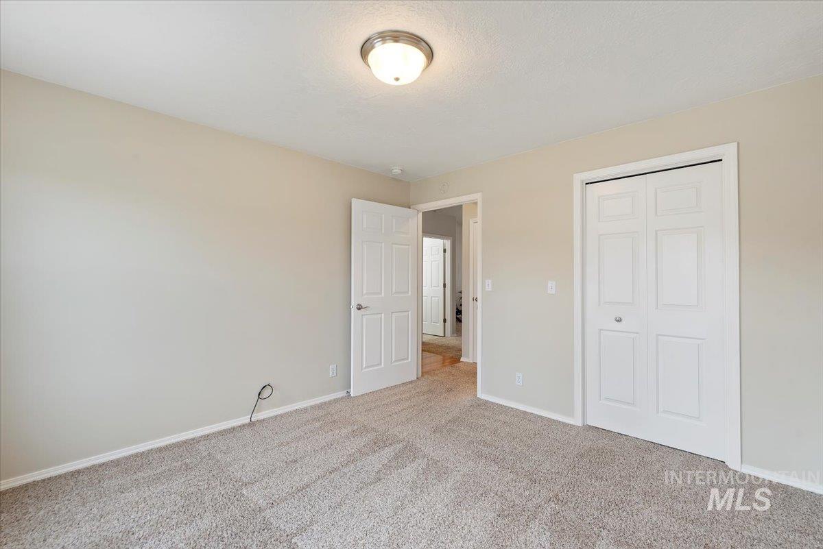 Unfurnished bedroom with carpet floors, a closet, and a textured ceiling