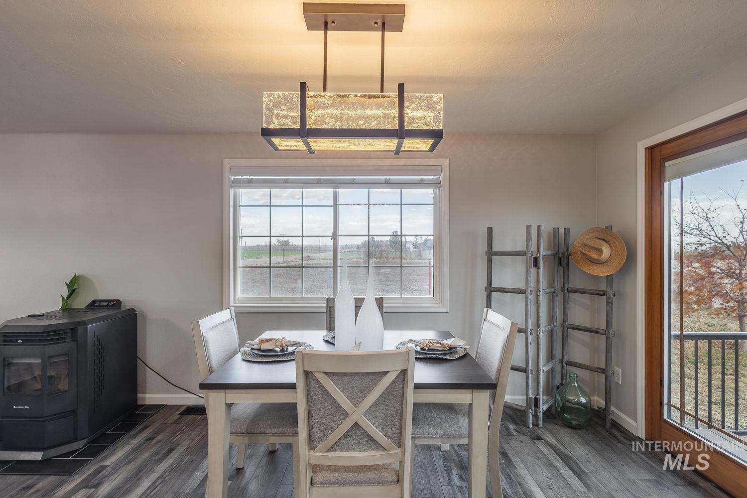Dining space with dark wood finished floors and a wood stove