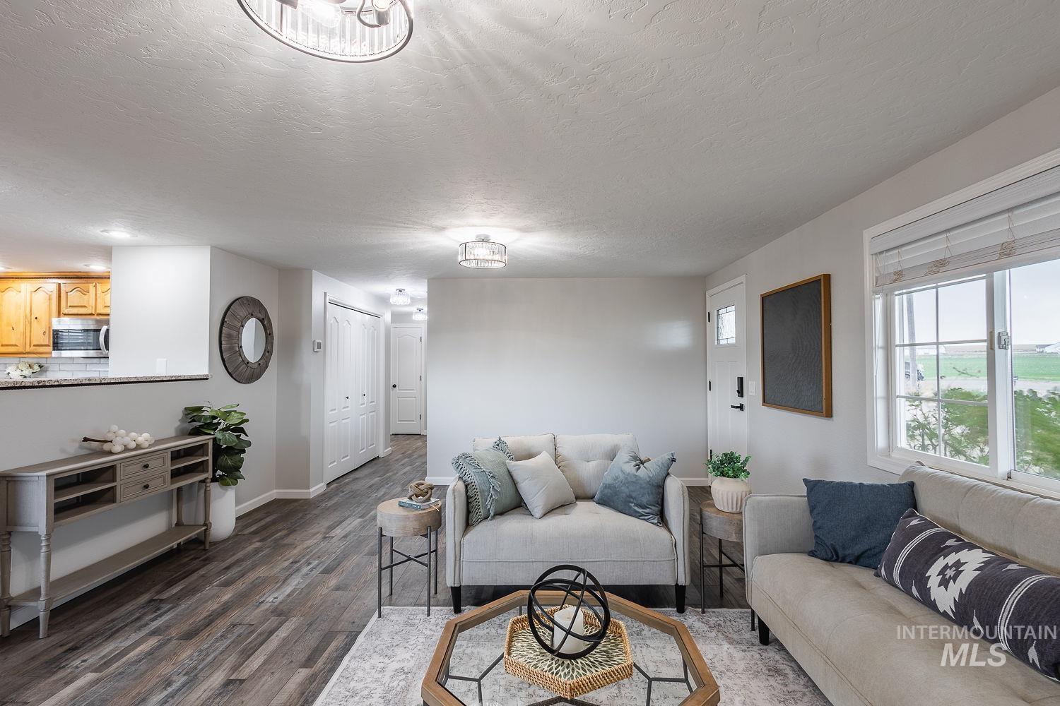 Living room featuring dark wood-style floors and a textured ceiling
