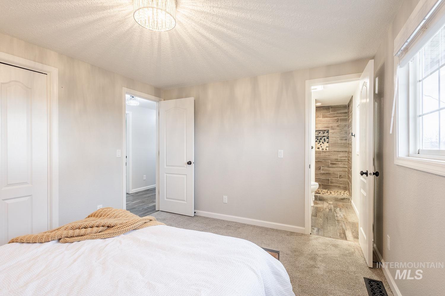 Bedroom featuring carpet flooring, a textured ceiling, and a closet