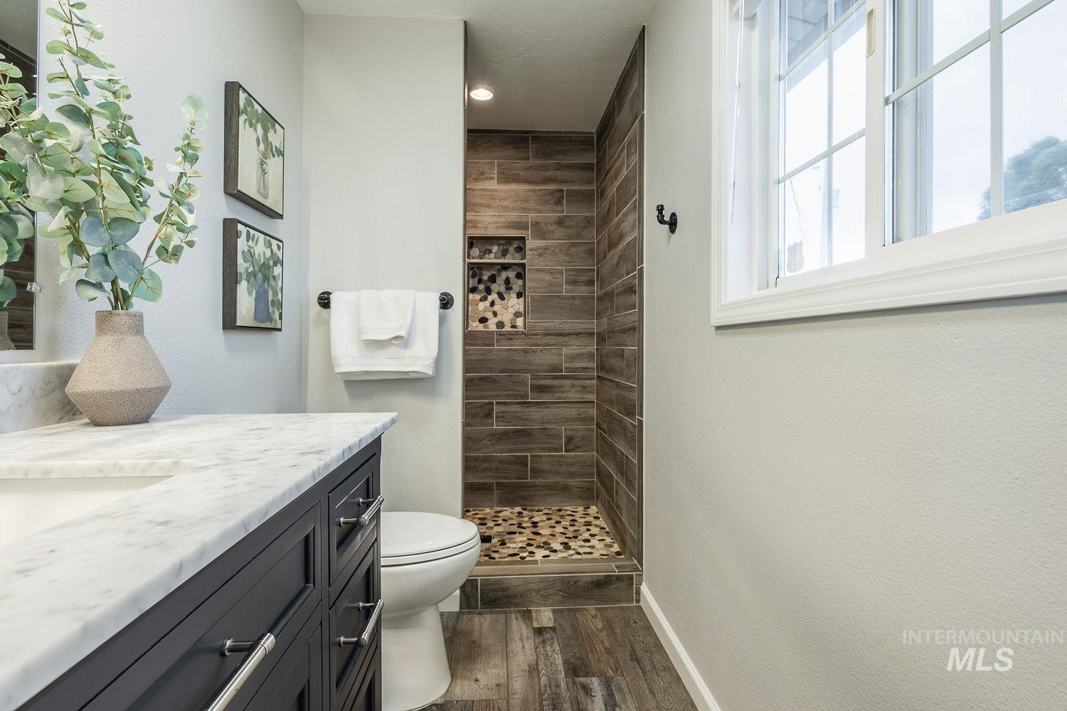 Bathroom with vanity, a shower stall, and dark wood finished floors