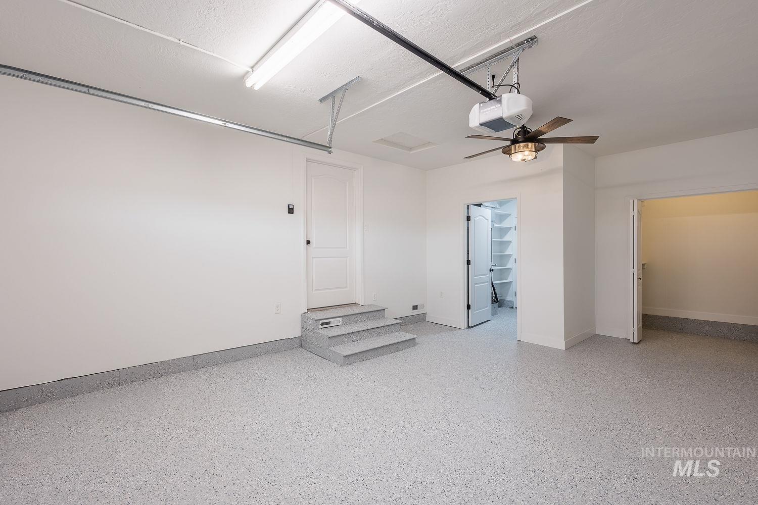 Garage with a garage door opener and a ceiling fan