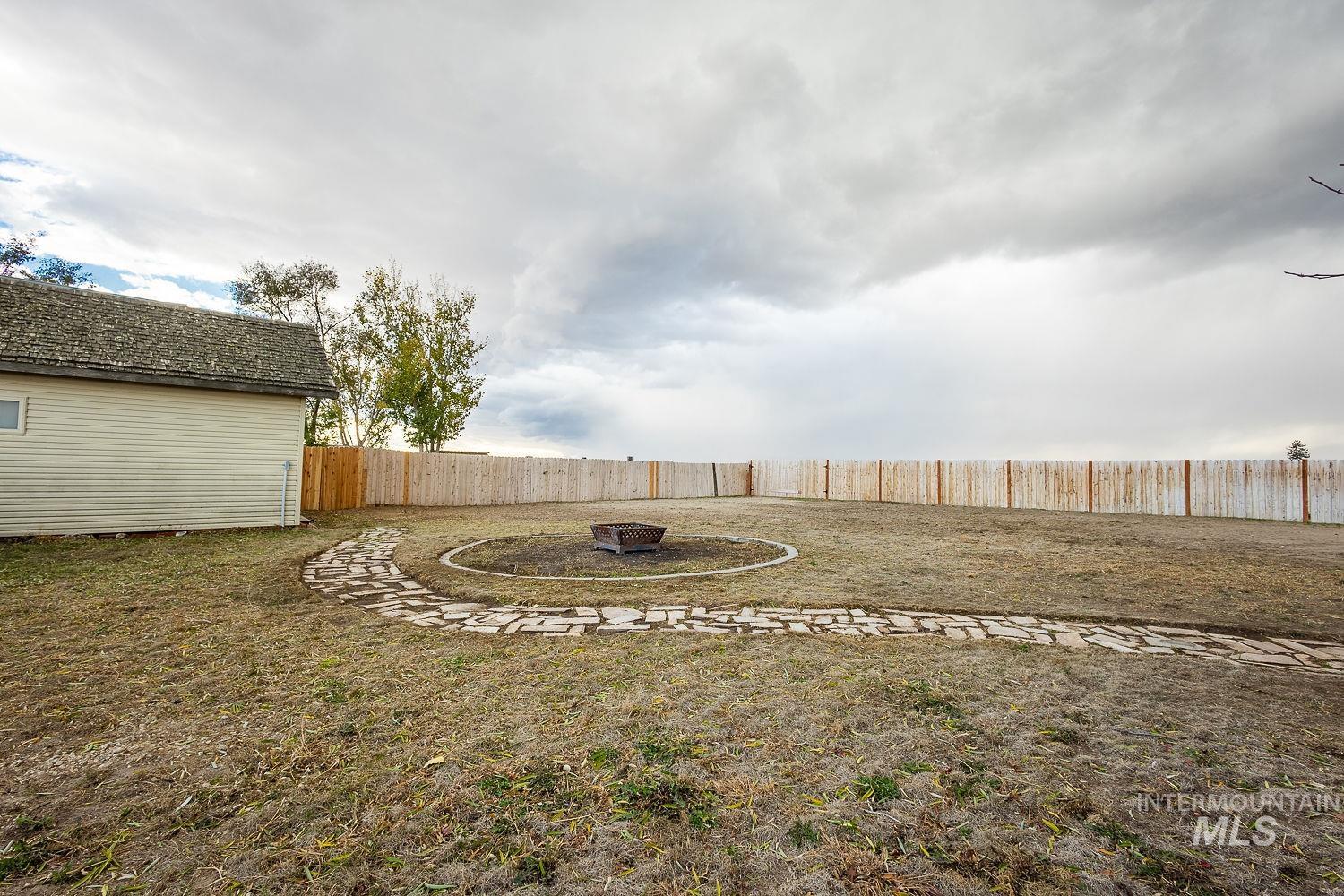 Fenced backyard with an outdoor fire pit and a patio