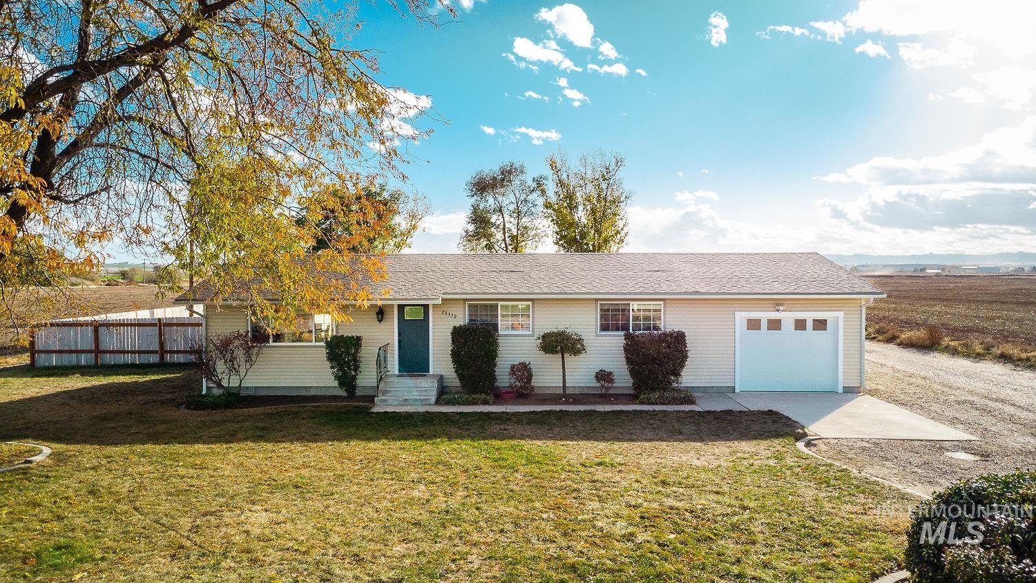 Ranch-style house featuring a shingled roof, concrete driveway, and an attached garage