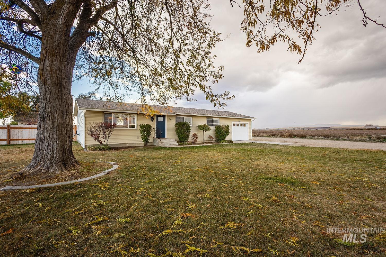 Ranch-style home with a garage, a front yard, and driveway