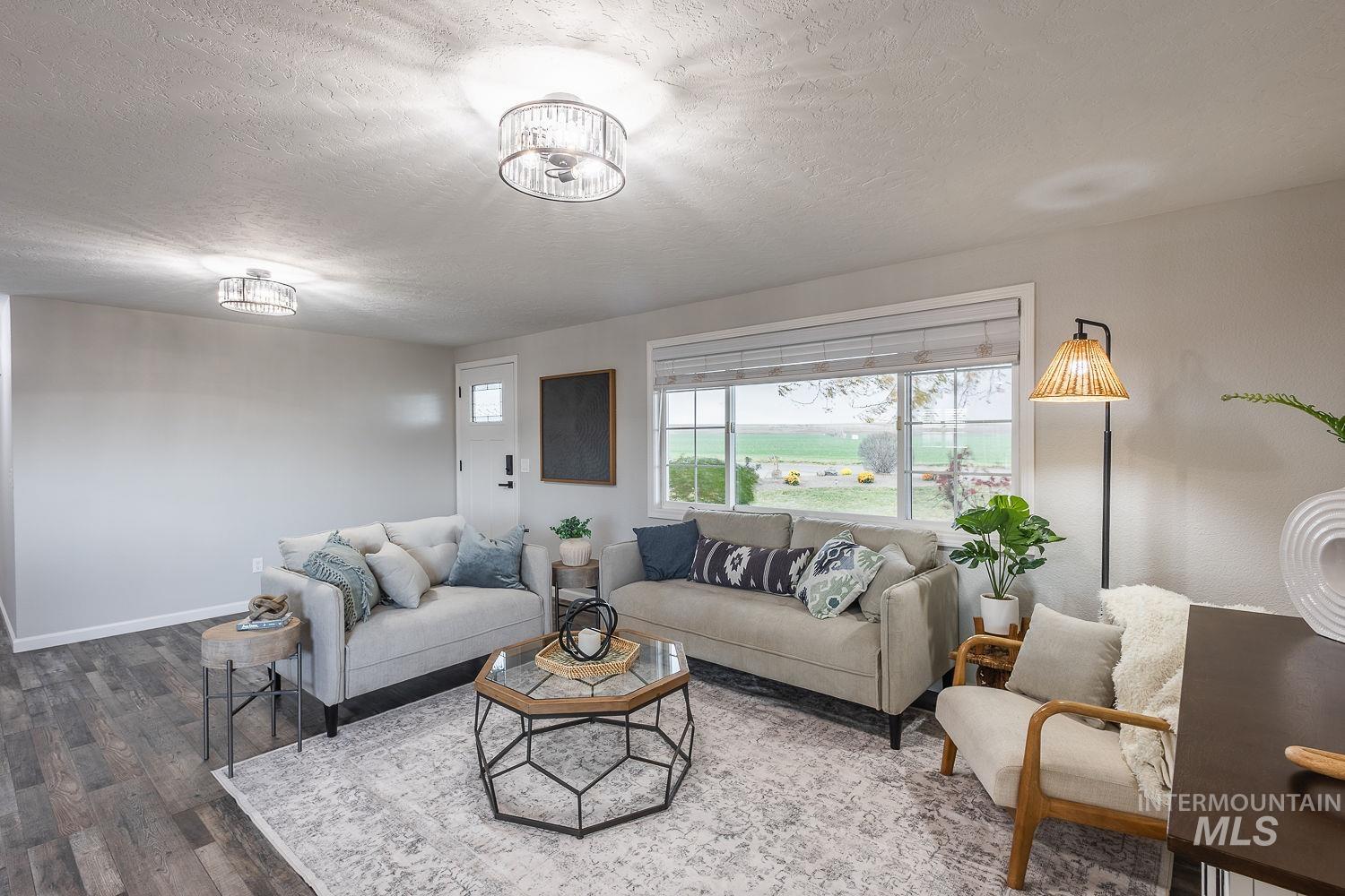 Living room with a textured ceiling and wood finished floors