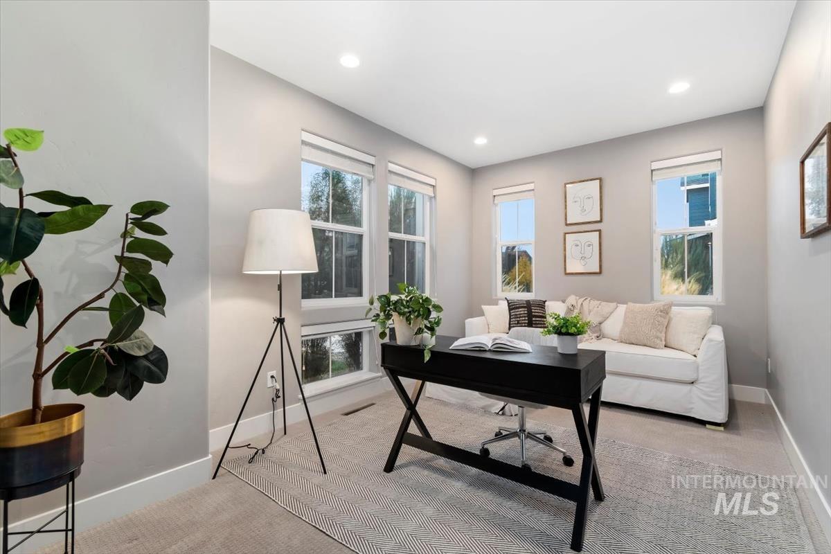 Office with light carpet, healthy amount of natural light, and recessed lighting