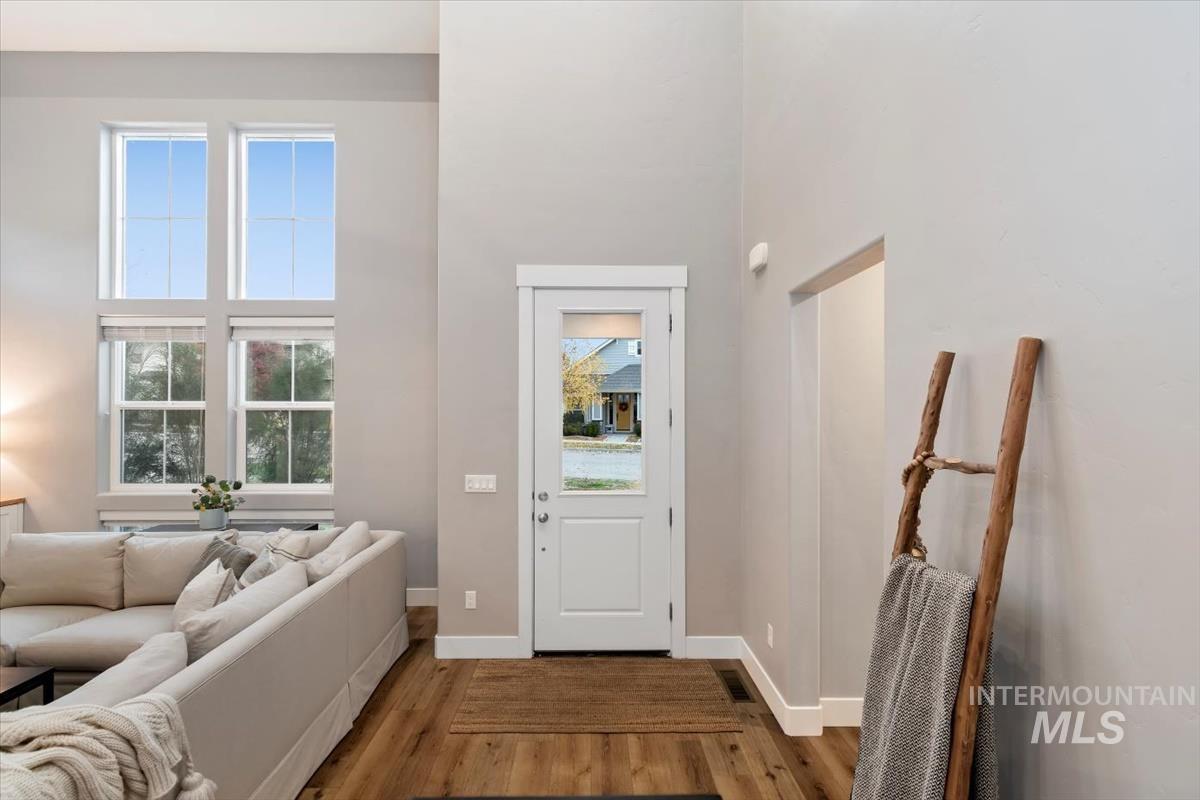 Foyer featuring wood finished floors, plenty of natural light, and a high ceiling