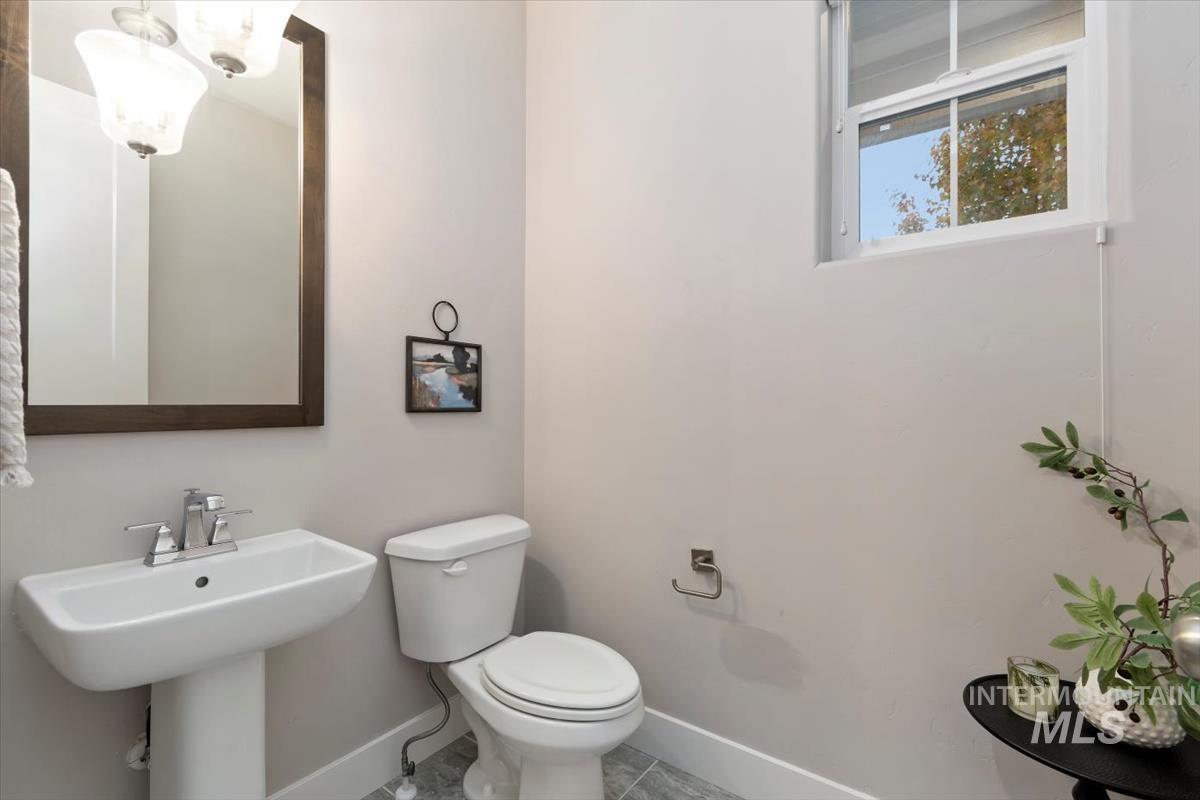 Half bathroom with baseboards and tile patterned floors