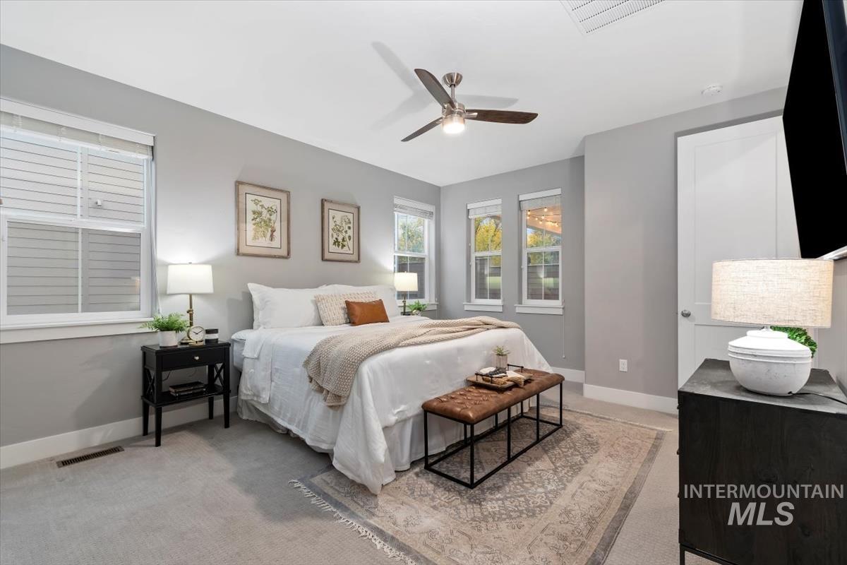 Bedroom featuring a ceiling fan and light colored carpet