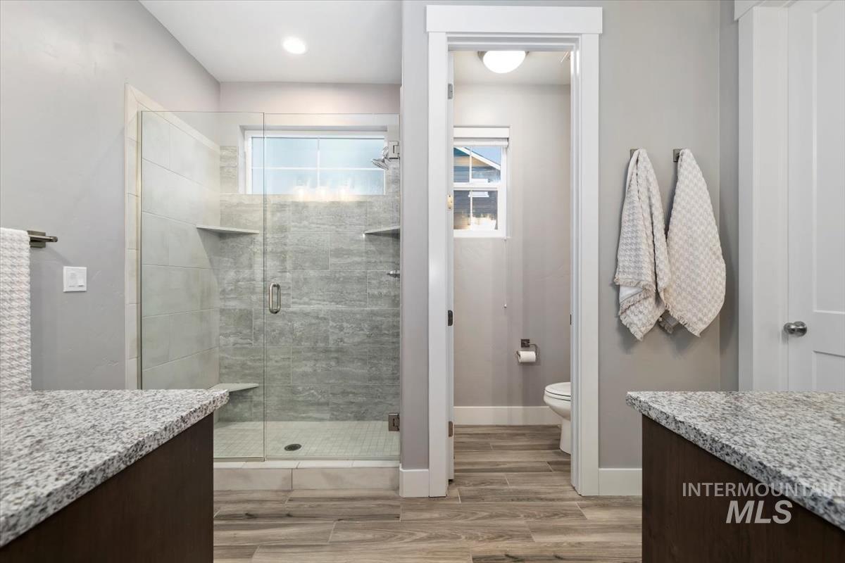 Bathroom with vanity, a stall shower, and light wood-style flooring