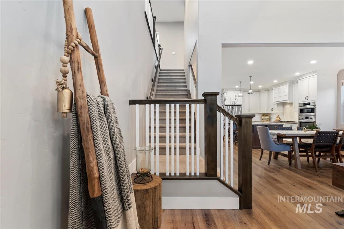 Staircase with wood finished floors and recessed lighting