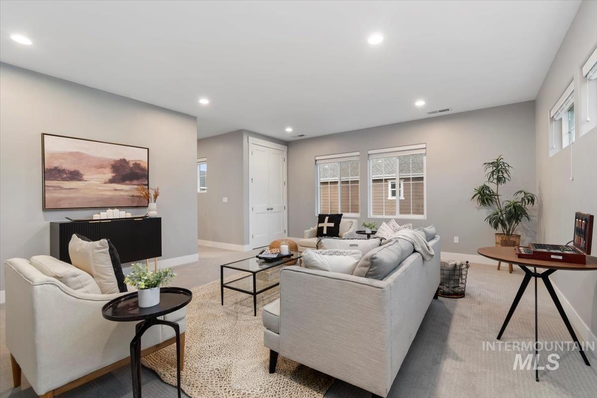 Carpeted living area with recessed lighting and healthy amount of natural light