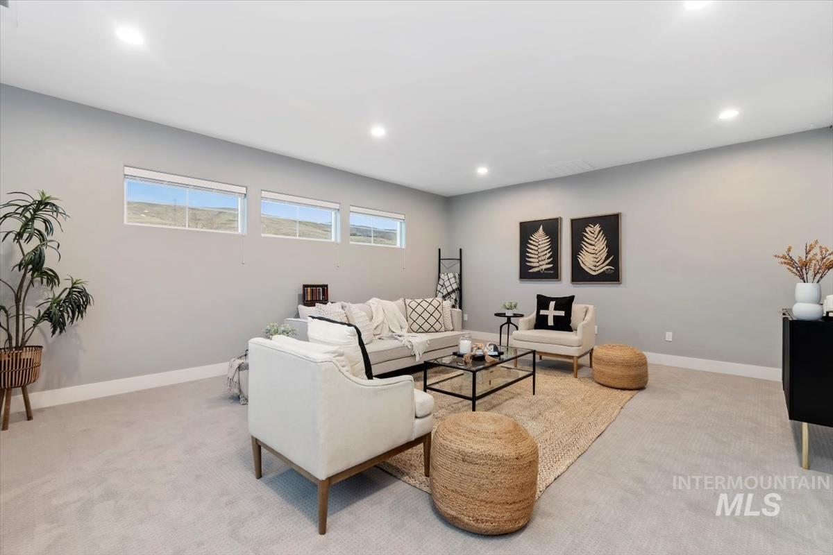 Carpeted living area with baseboards and recessed lighting