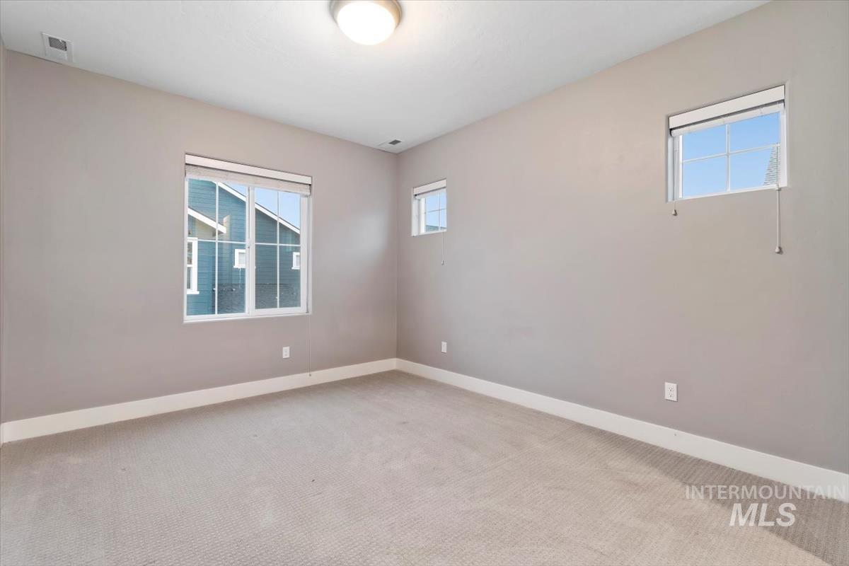 Carpeted spare room with healthy amount of natural light