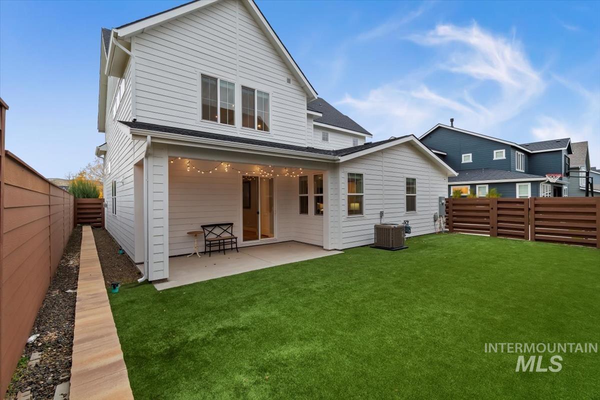 Rear view of property featuring a patio area, a fenced backyard, and a shingled roof