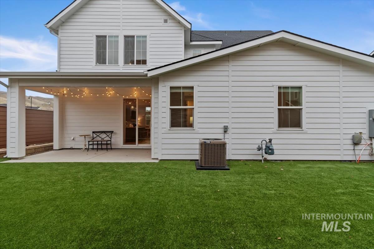 Rear view of property featuring a patio area and roof with shingles