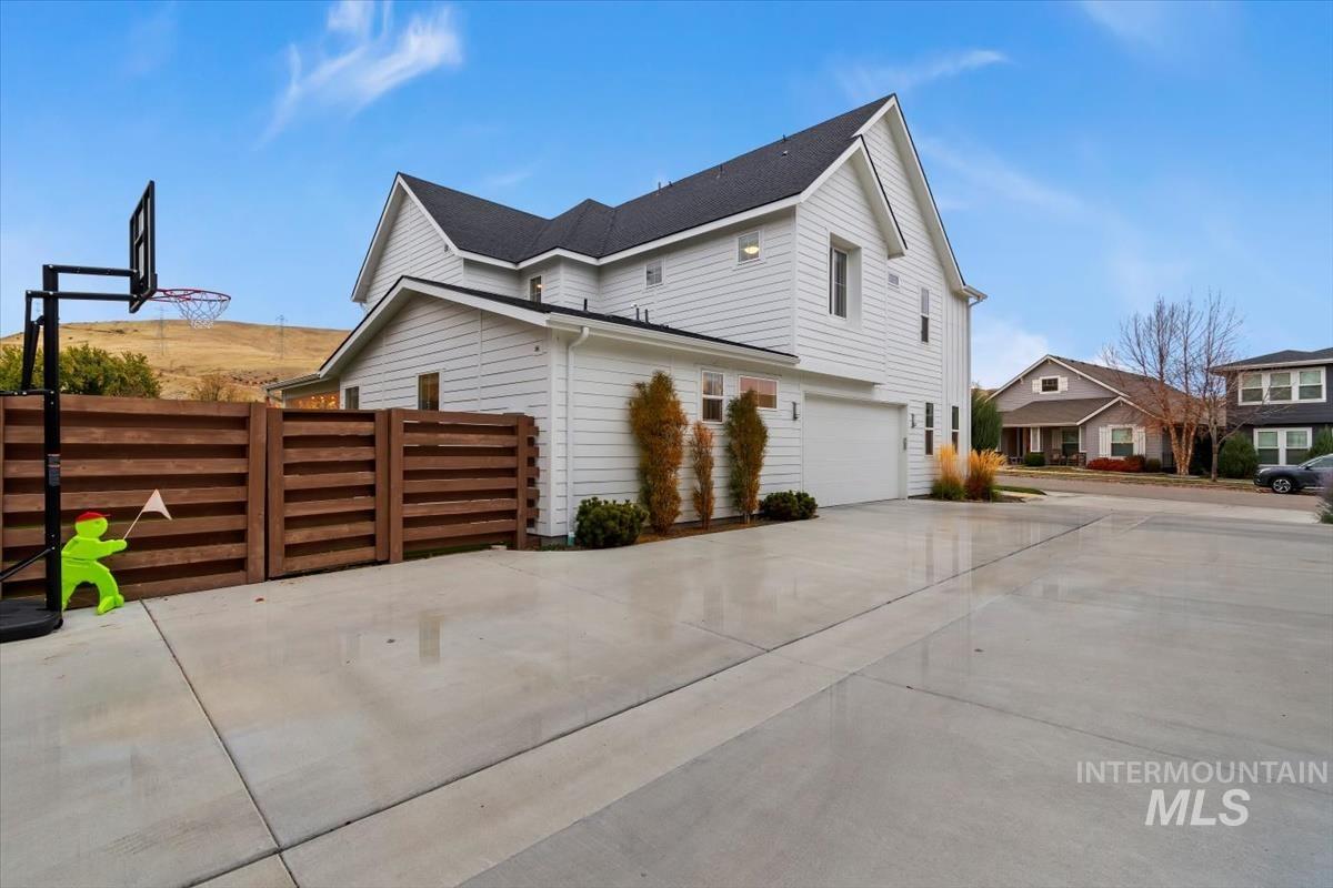 View of side of property with an attached garage and concrete driveway