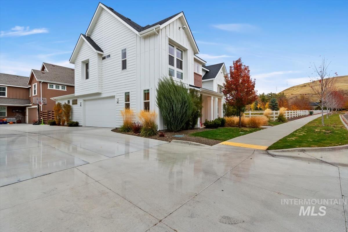View of property exterior with board and batten siding, concrete driveway, and an attached garage