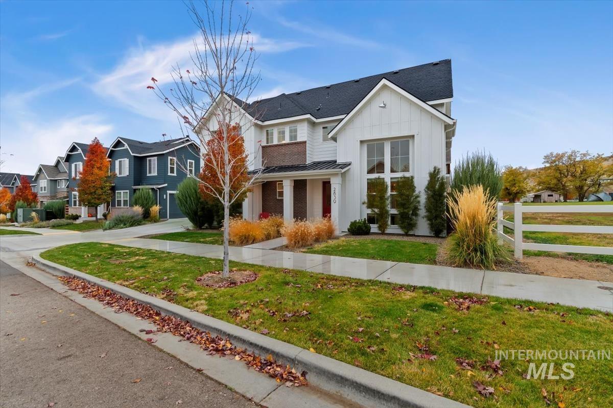 View of front facade with board and batten siding, a standing seam roof, a metal roof, a porch, and roof with shingles