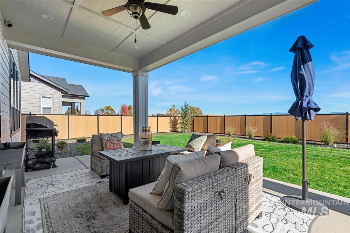 Fenced backyard with a patio area, area for grilling, a ceiling fan, and outdoor lounge area