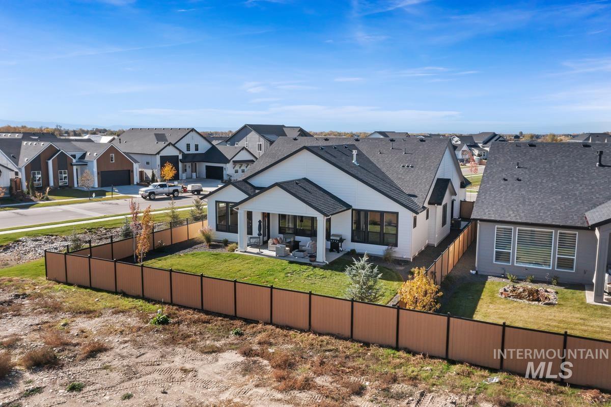 Back of house featuring a residential view, a fenced backyard, a patio area, a shingled roof, and an outdoor living space