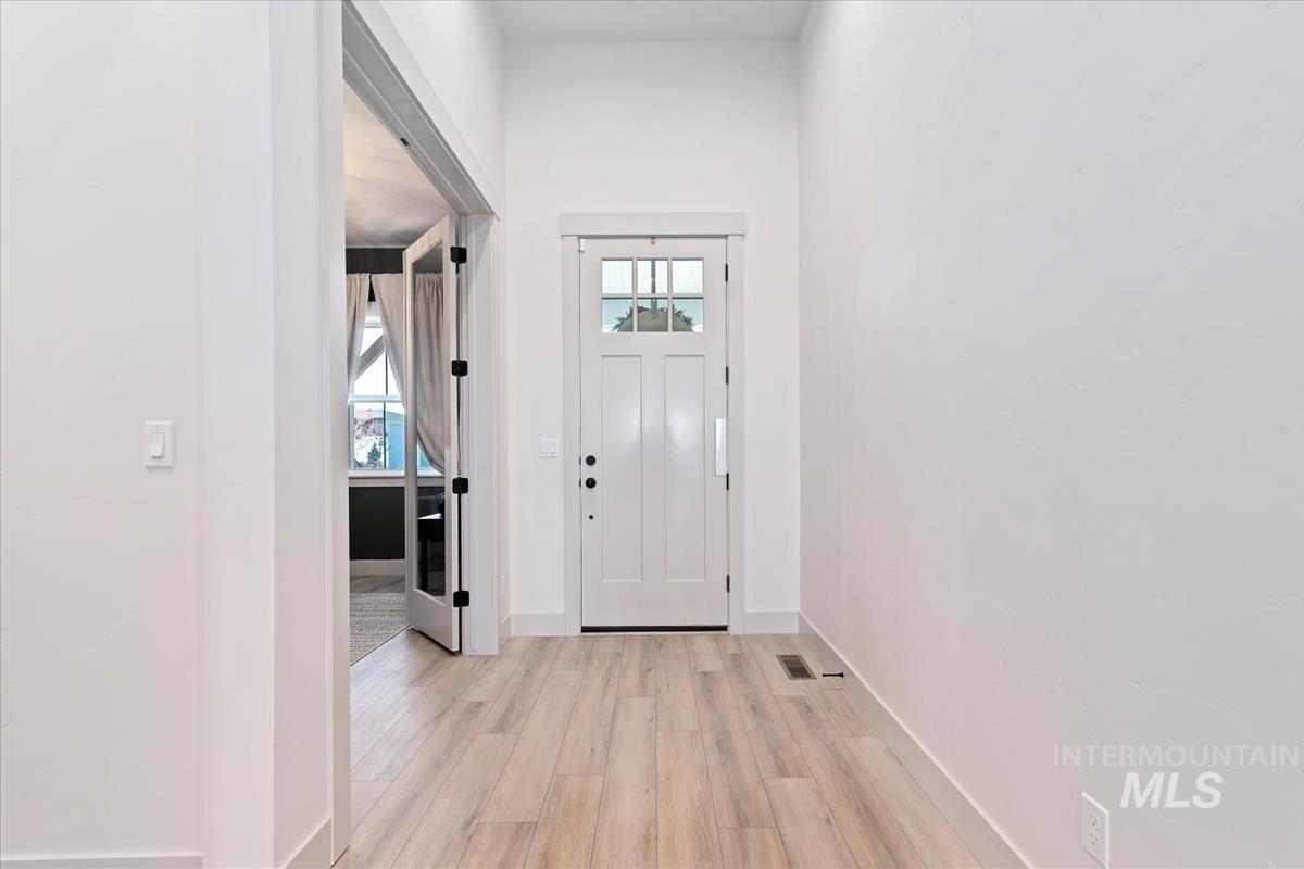 Foyer entrance featuring light wood-style floors and baseboards