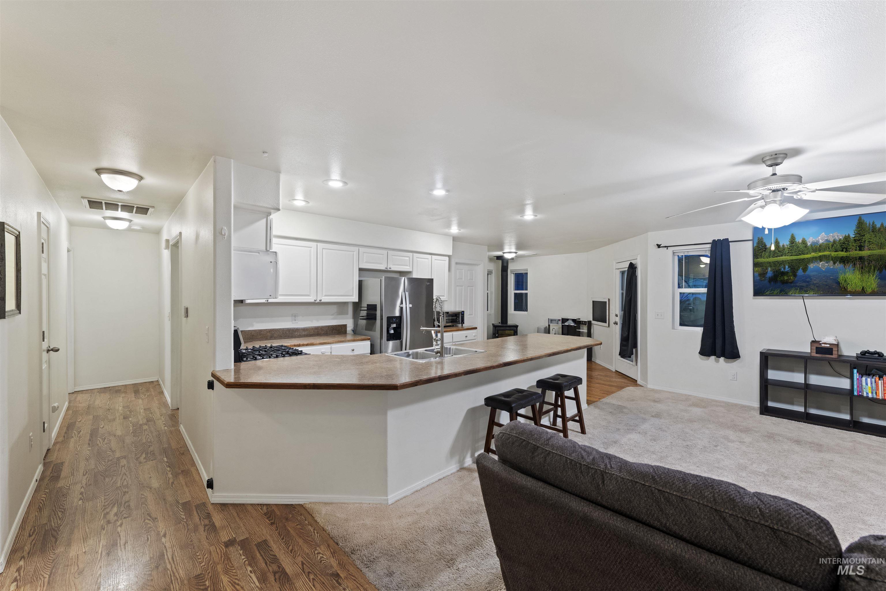 Kitchen with white cabinetry, light wood-type flooring, open floor plan, and a peninsula