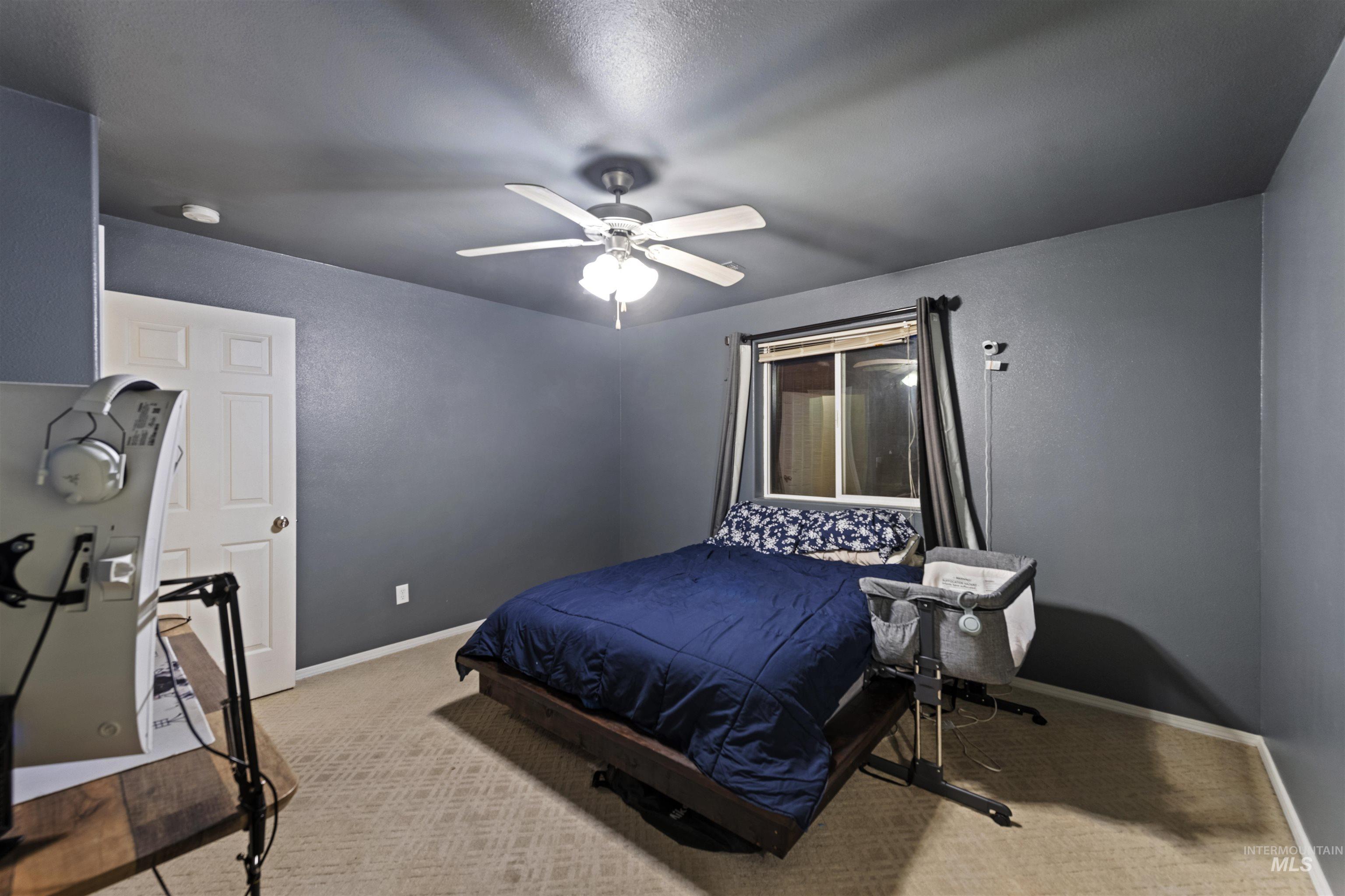 Bedroom featuring light colored carpet and a ceiling fan