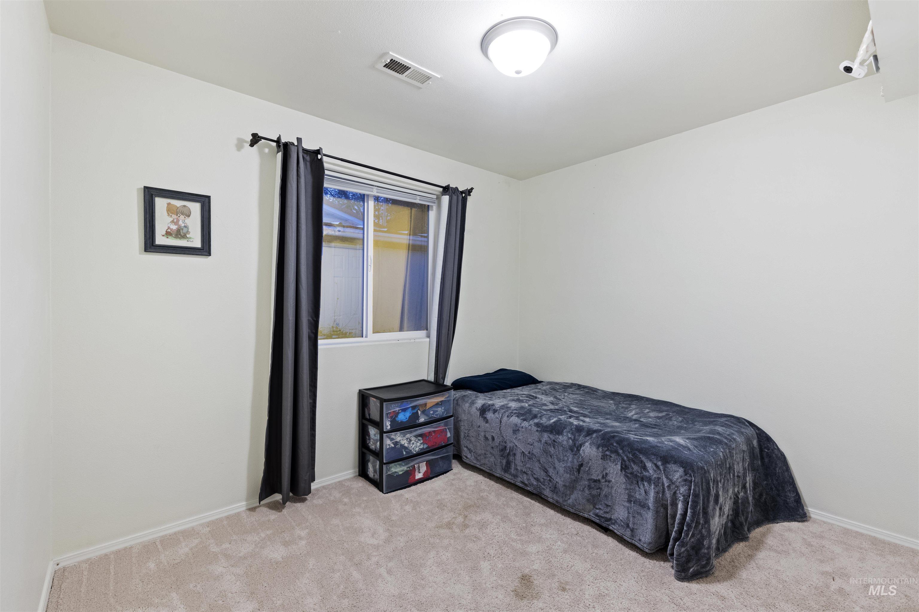 Bedroom with light carpet and baseboards