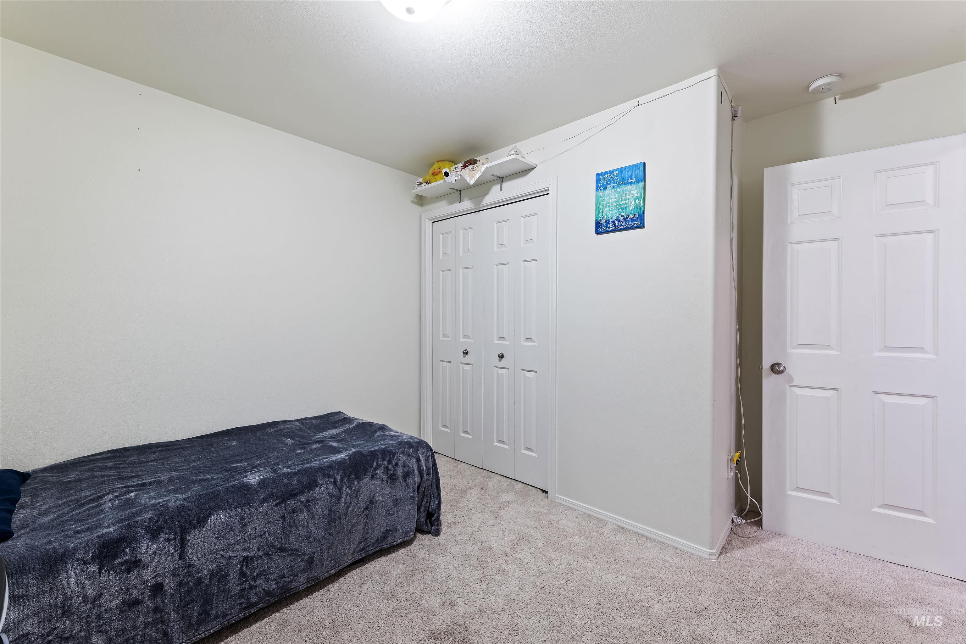 Carpeted bedroom with a closet and baseboards