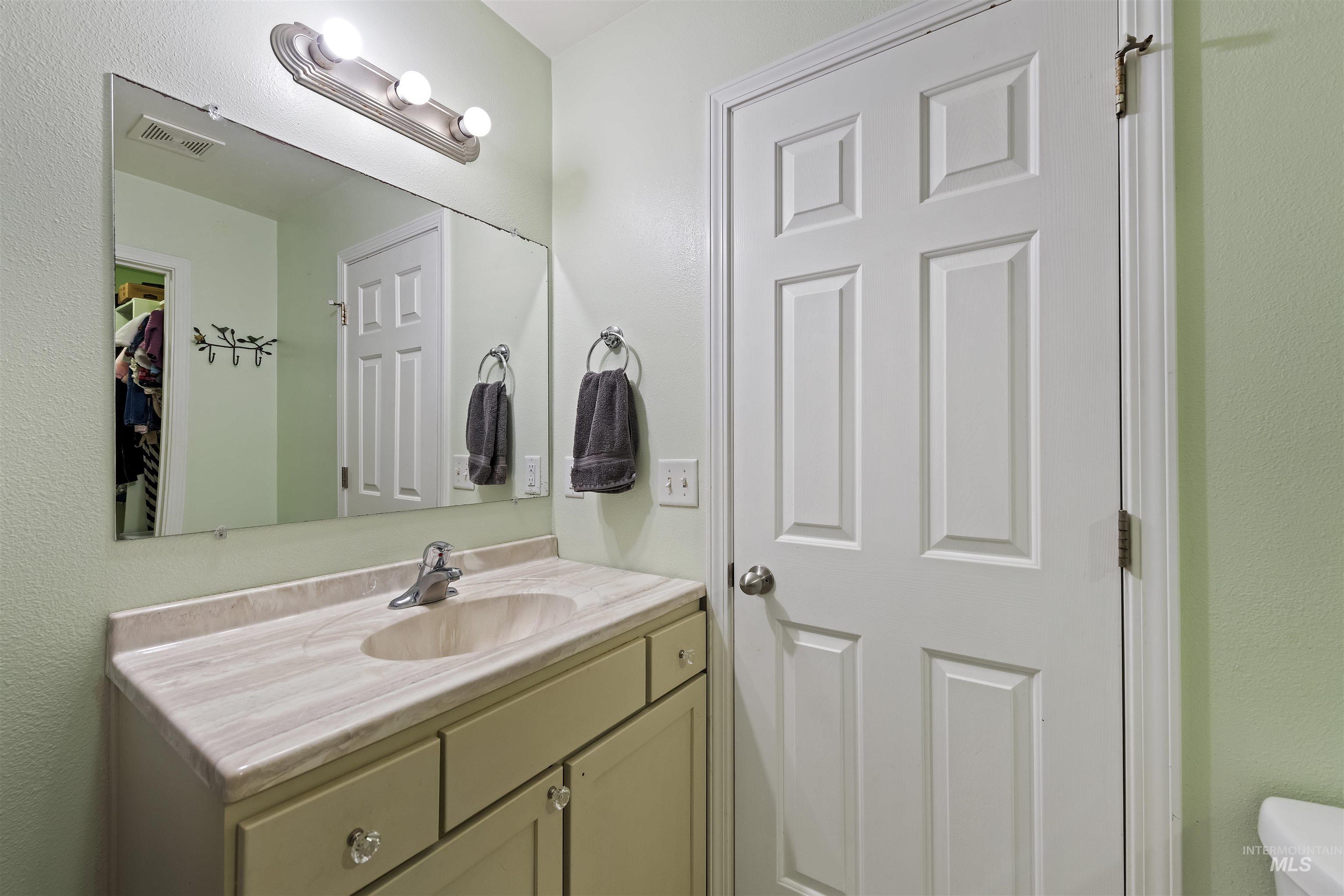 Bathroom featuring vanity and a textured wall