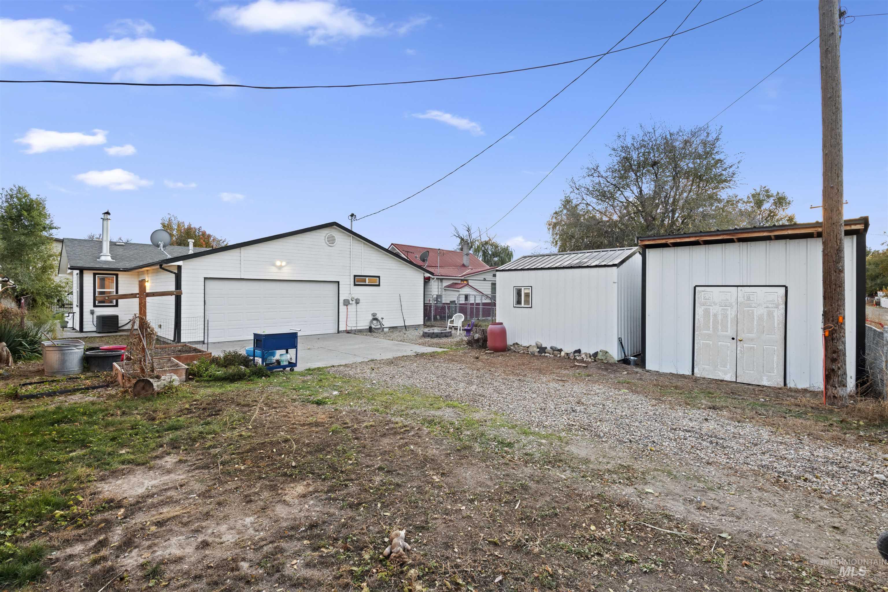 Rear view of house featuring a patio area, board and batten siding, and a storage unit