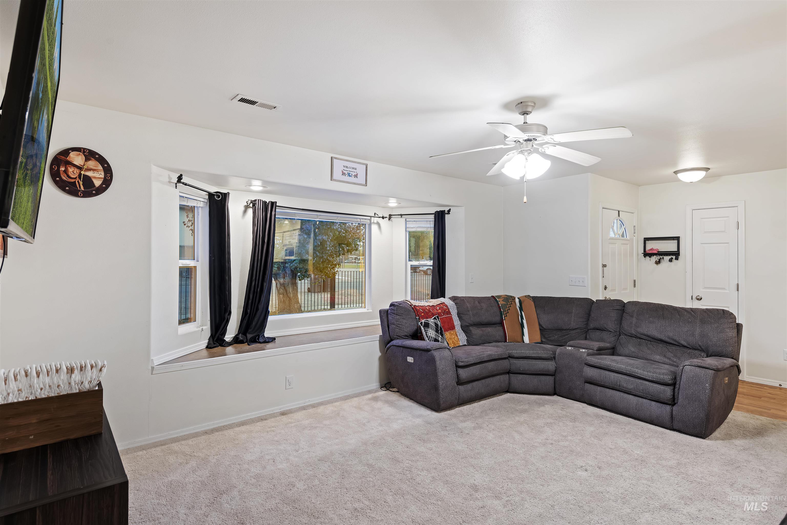 Living room featuring light colored carpet and ceiling fan