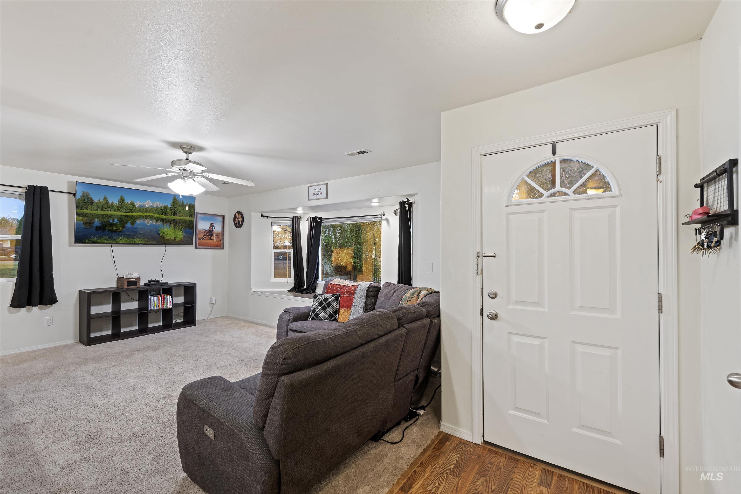 Foyer entrance with ceiling fan and wood finished floors