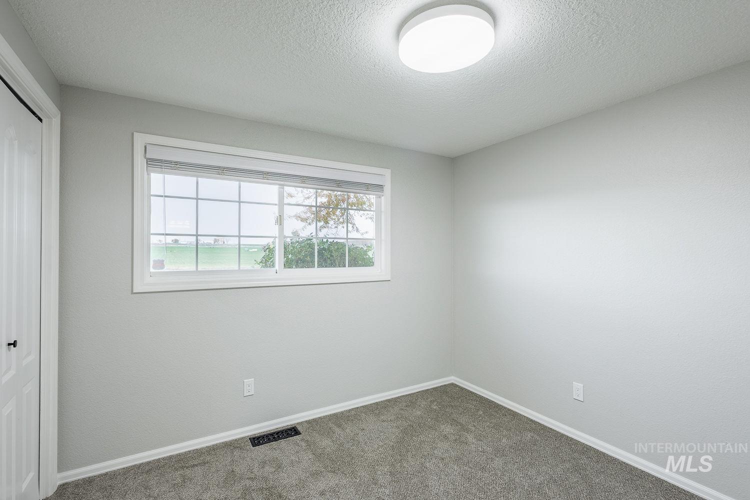 Unfurnished bedroom featuring a closet, carpet floors, and a textured ceiling