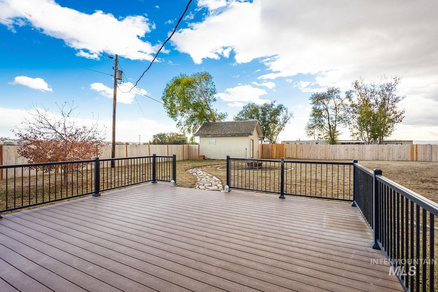 Deck with an outbuilding and a fenced backyard