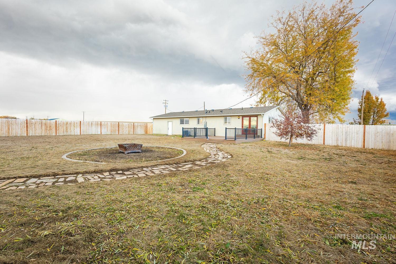 Rear view of house featuring a fenced backyard, an outdoor fire pit, and a patio