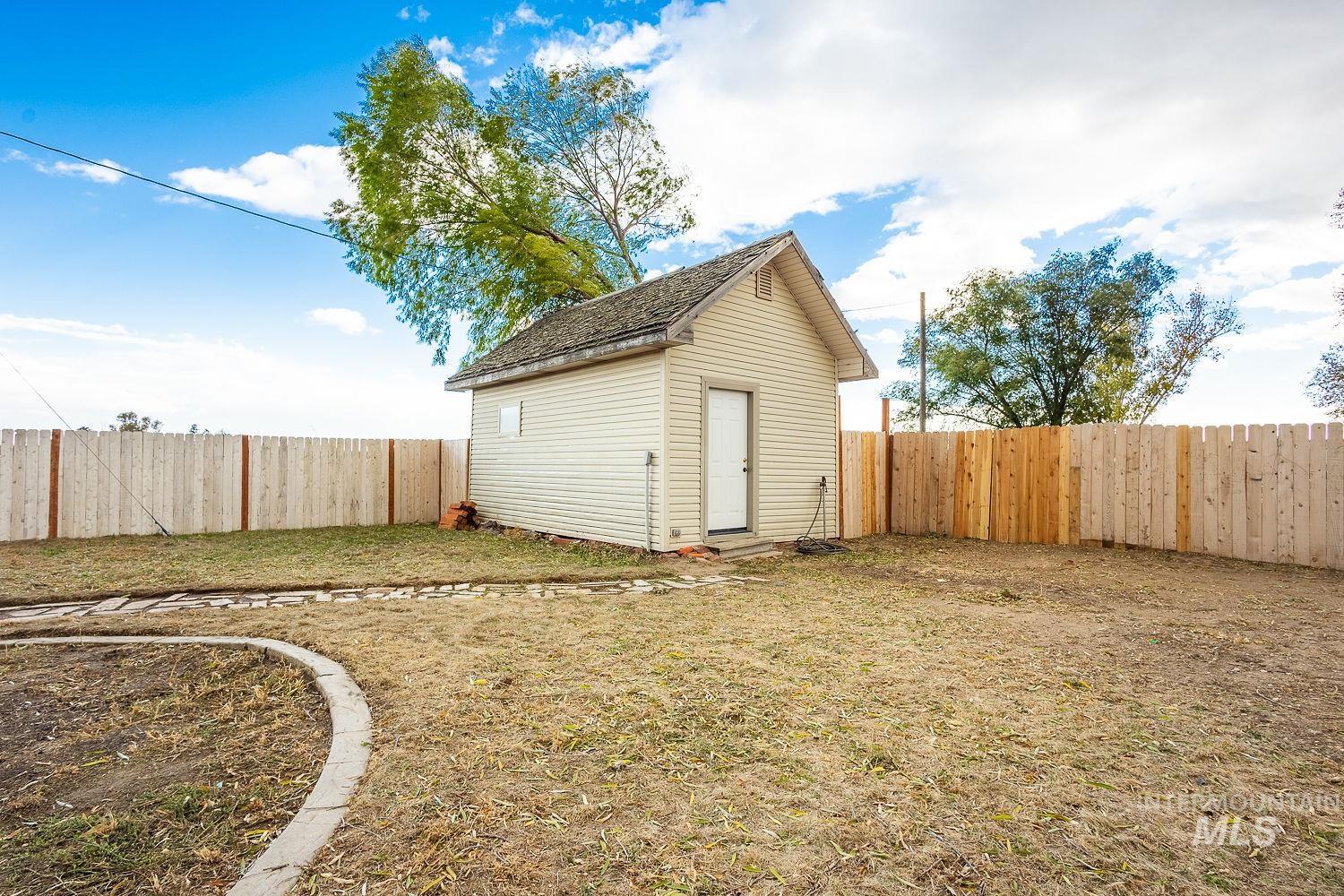 Fenced backyard with an outdoor structure