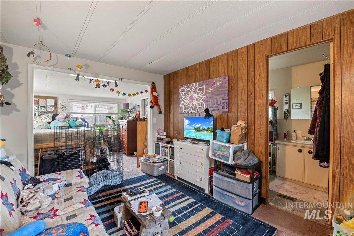 Bedroom with wood walls and dark colored carpet