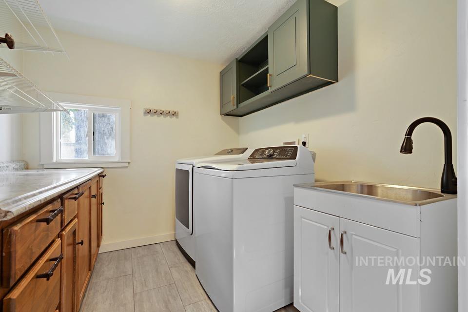 Washroom featuring cabinet space and washing machine and clothes dryer