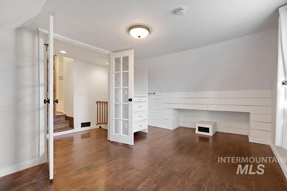 Unfurnished office with lofted ceiling and dark wood finished floors