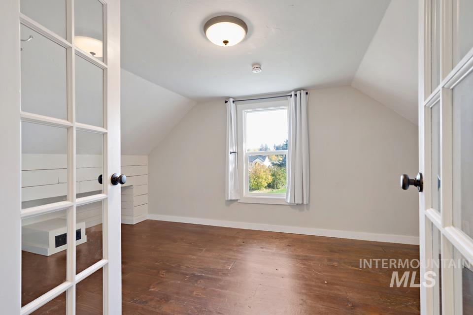Bonus room featuring dark wood-type flooring and lofted ceiling