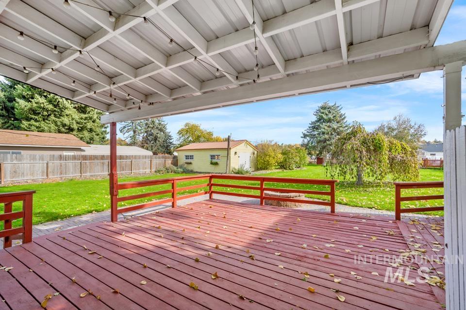 Wooden terrace with an outbuilding and a fenced backyard