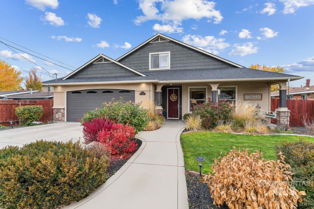 Craftsman-style house with a porch, concrete driveway, an attached garage, stone siding, and a shingled roof