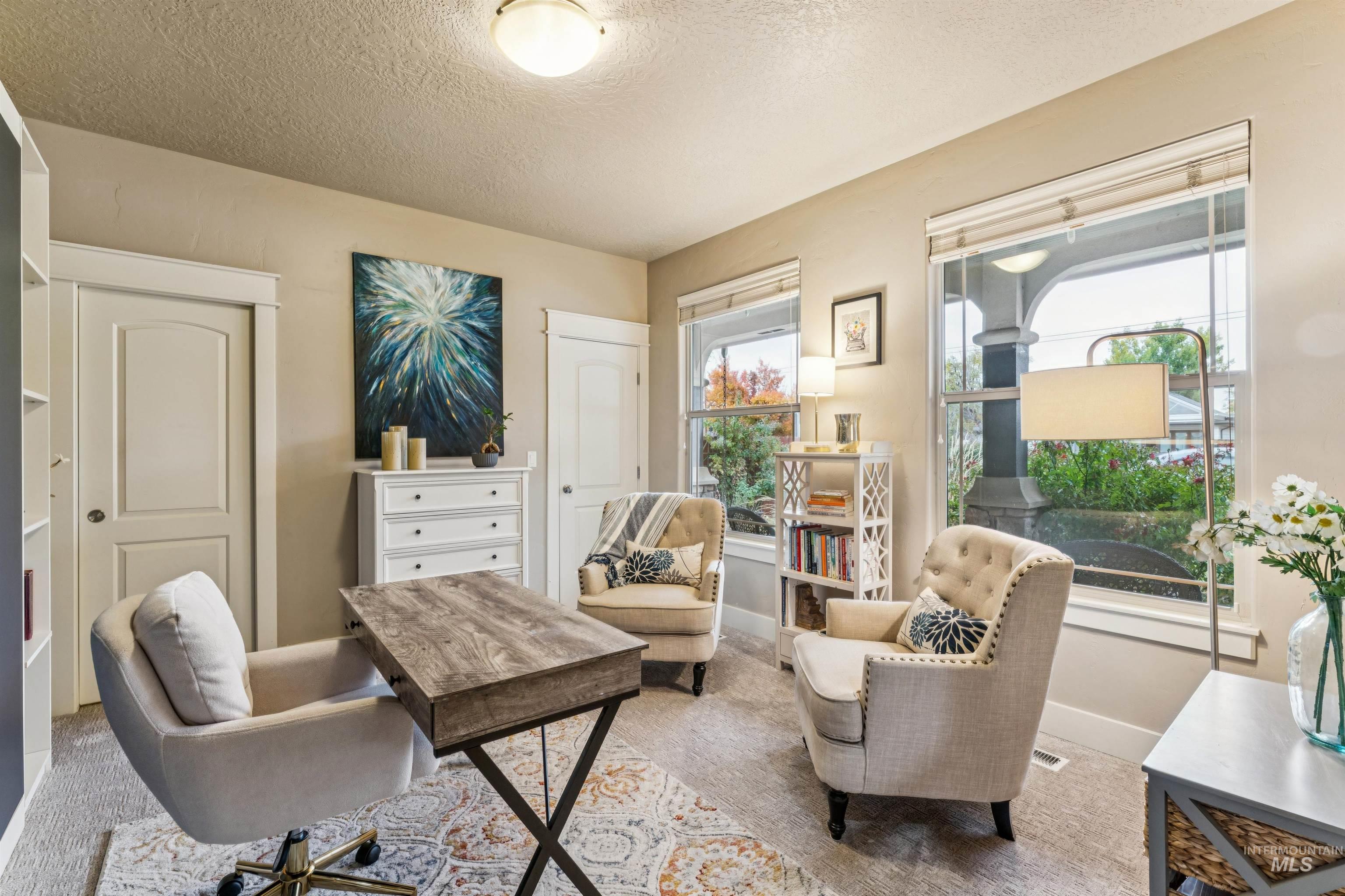 Home office with a textured ceiling and carpet
